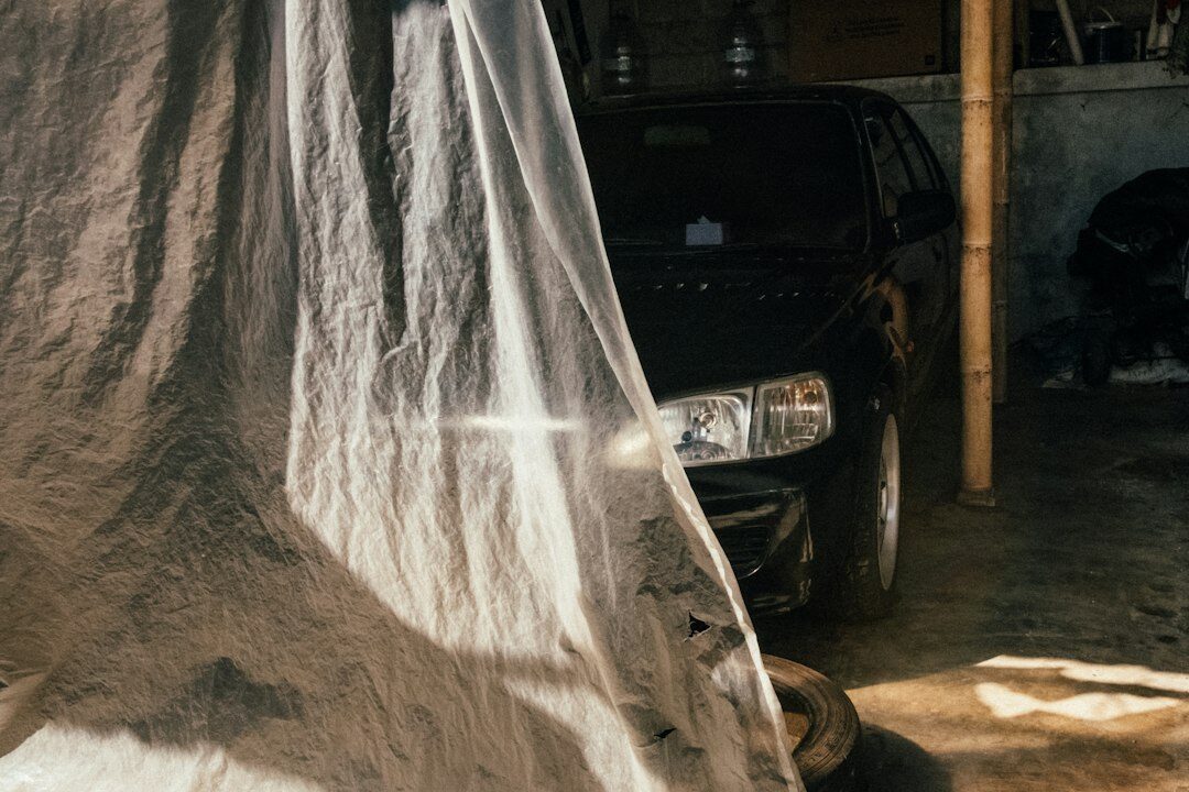 Dimly lit private garage with covered automobiles under dust sheets