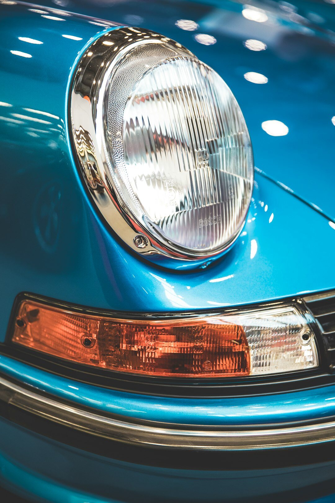 Close-up of a polished vintage automobile grille and headlight