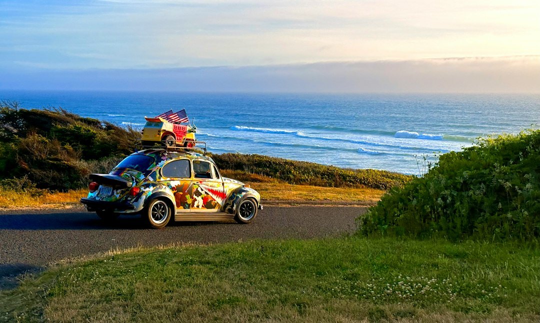 Vintage sports car driving along a coastal road near Punta del Este at dusk